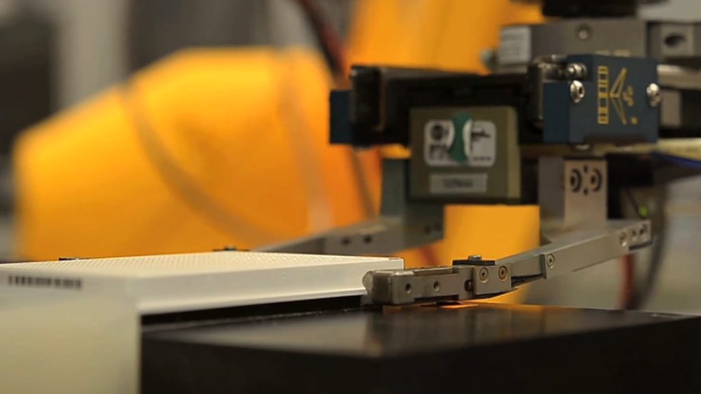 A robot arm handling a laboratory sample plate.